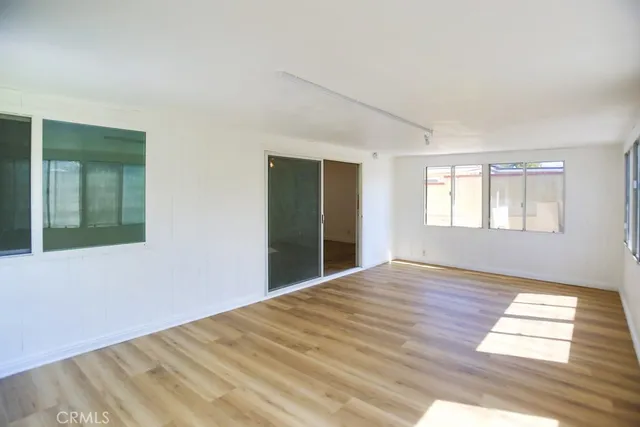 a backyard of a house with plants and large tree