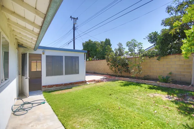 a view of an house with backyard and a tree