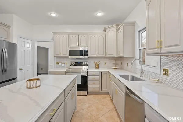 a kitchen with a sink a stove a refrigerator a center island and a window