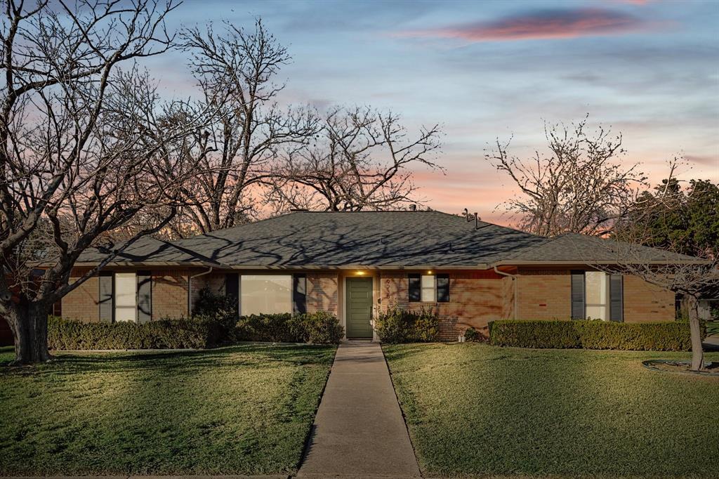 9235 Orbiter Drive Dallas, TX 75243 - Photo 1 of 1 a front view of a house with a garden and lake view