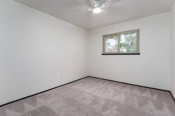 an empty room with a chandelier fan