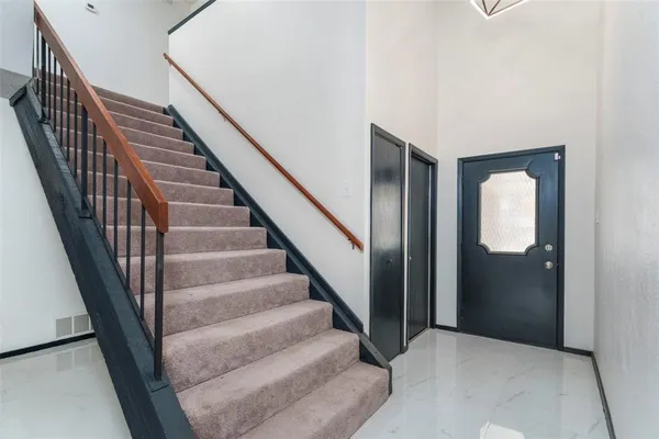 a view of staircase with wooden floor and white walls