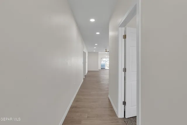 an empty room with a window and a fan