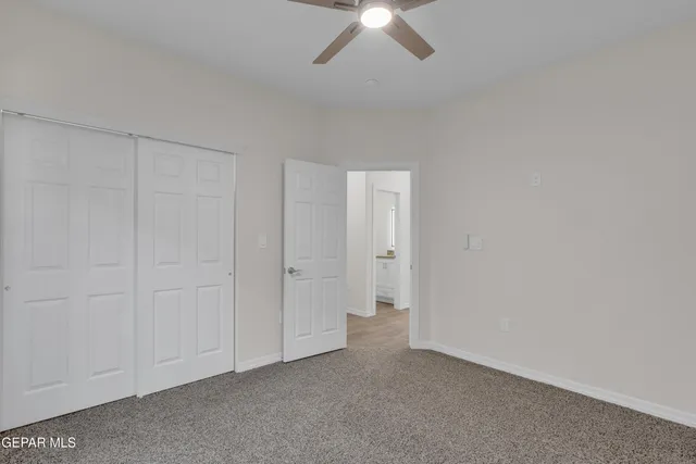 an empty room with a window and a fan