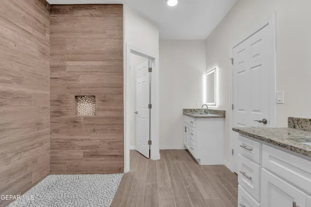 a bathroom with a granite countertop sink and a mirror