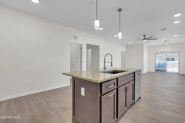 a kitchen with a sink a counter space and wooden floor