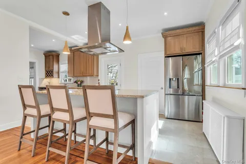 a kitchen with stainless steel appliances kitchen island granite countertop a refrigerator and chairs