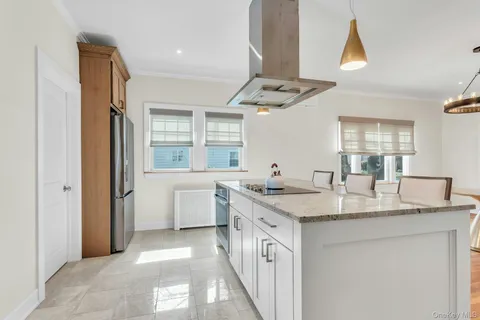 a bathroom with a granite countertop sink a toilet a mirror and window