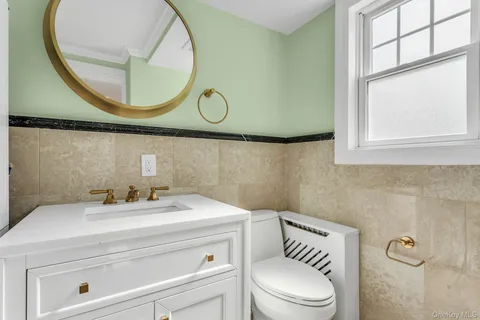 a bathroom with a sink a toilet and a mirror