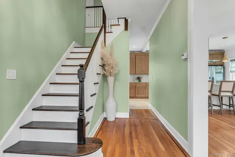 a view of entryway and hall with wooden floor
