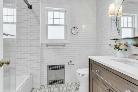 a bathroom with a sink a toilet and mirror