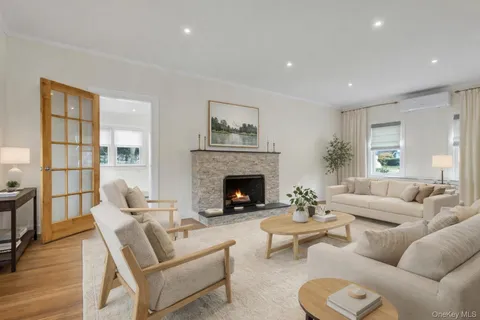 a living room with furniture a fireplace and a large window