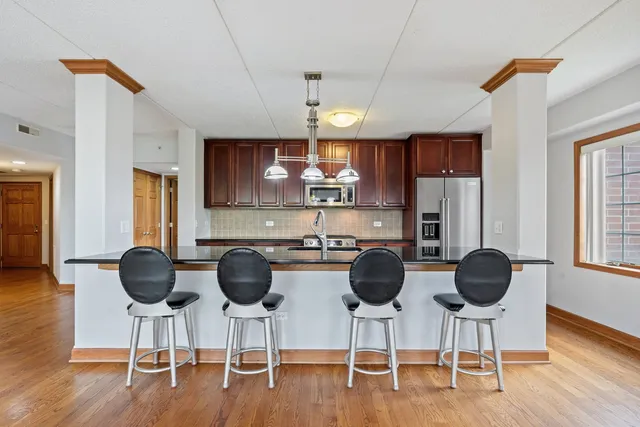 a kitchen with stainless steel appliances a dining table chairs and granite counter tops