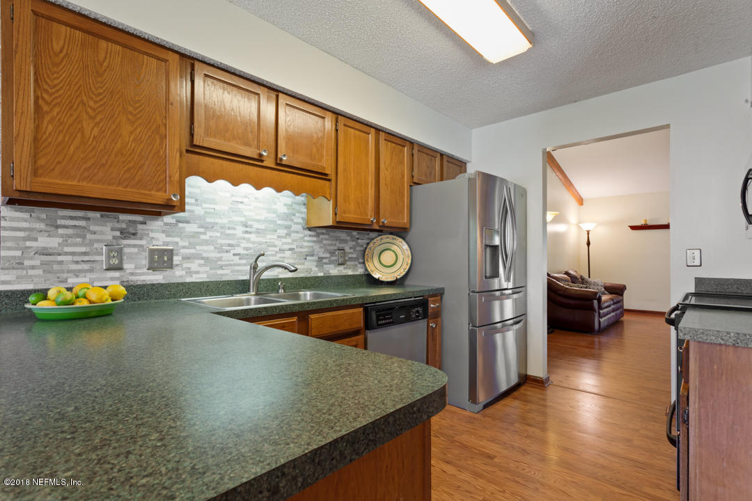 10836 Reading Road Jacksonville, FL 32257 - Photo 10 of 32 a kitchen with a refrigerator a stove and a wooden cabinets