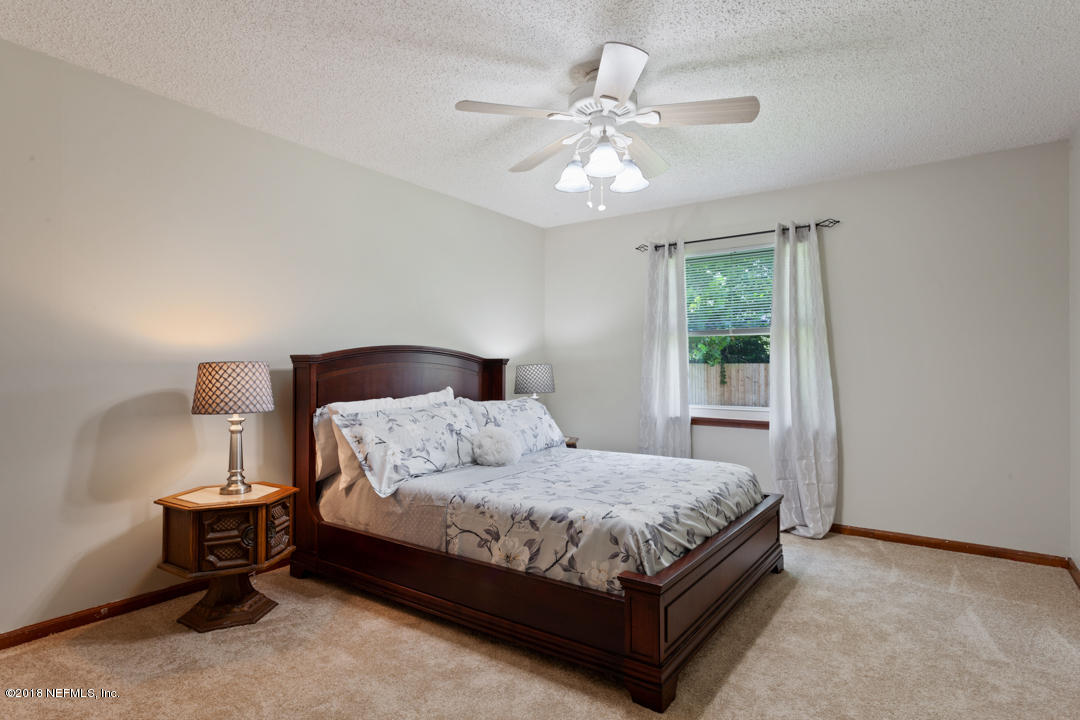 10836 Reading Road Jacksonville, FL 32257 - Photo 12 of 32 a bedroom with a bed and a chandelier