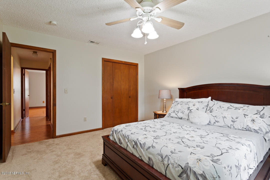 10836 Reading Road Jacksonville, FL 32257 - Photo 13 of 32 a bedroom with a bed and a chandelier