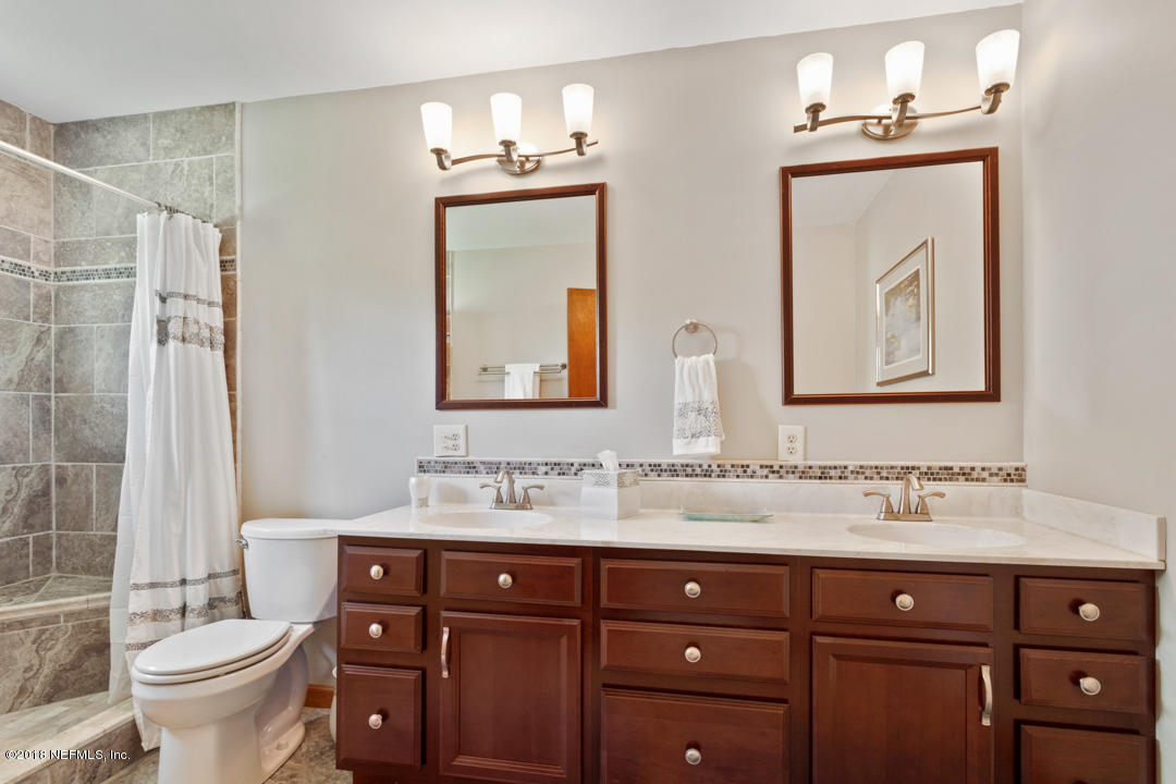 10836 Reading Road Jacksonville, FL 32257 - Photo 17 of 32 a bathroom with a double vanity sink toilet and a mirror