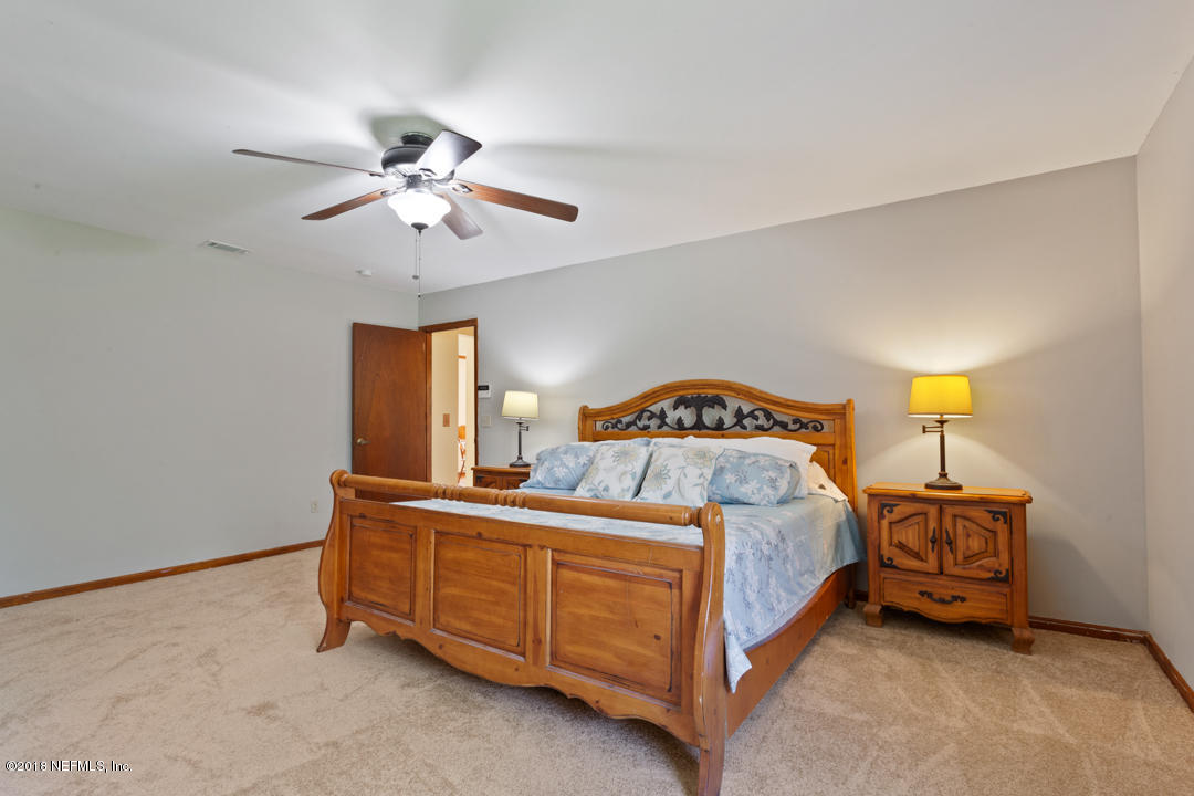10836 Reading Road Jacksonville, FL 32257 - Photo 21 of 32 a bedroom with a bed and a chandelier