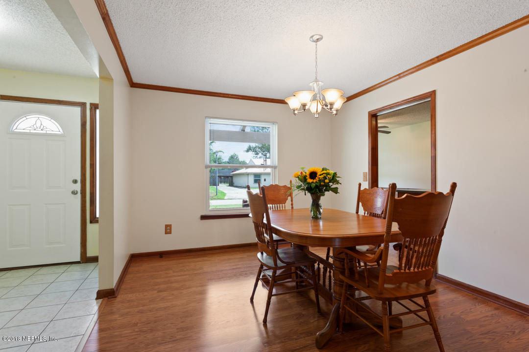 10836 Reading Road Jacksonville, FL 32257 - Photo 7 of 32 a dining room with furniture a chandelier and wooden floor