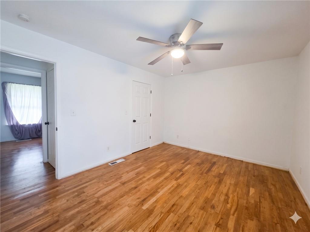 1929 Wee Kirk Road Southeast Atlanta, GA 30316 - Photo 19 of 22 an empty room with wooden floor fan and windows