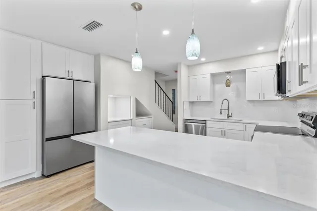 a view of an empty room with a fireplace and wooden floor