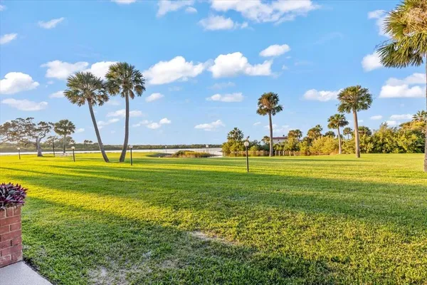 a view of an empty room with wooden floor and a ceiling fan