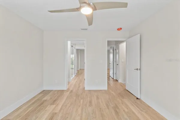 a view of wooden floor and chandelier fan in a room