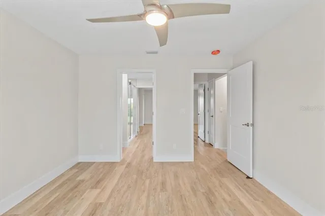 a view of wooden floor and chandelier fan in a room