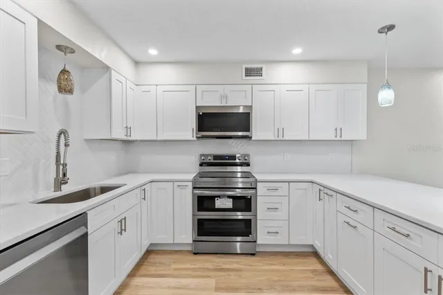 a kitchen with stainless steel appliances refrigerator stove microwave and cabinets