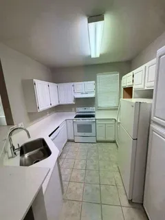 a kitchen with a refrigerator sink and cabinets