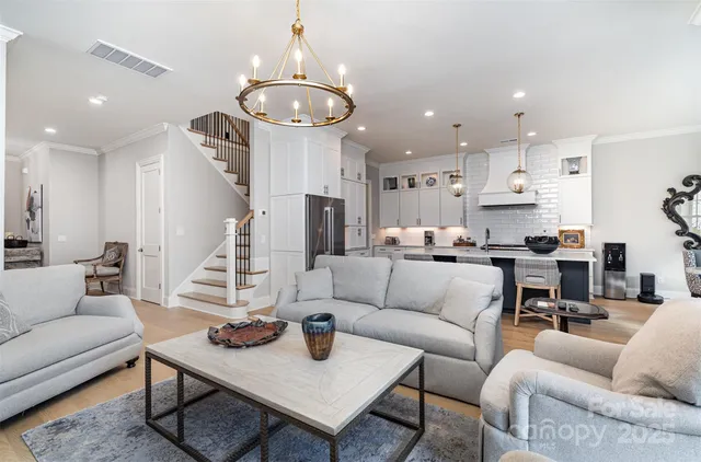 a living room with furniture kitchen and a chandelier