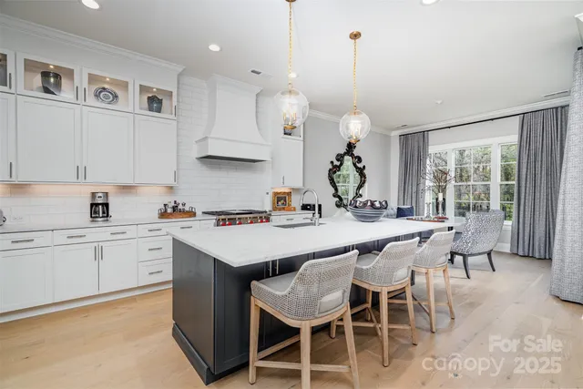 a kitchen with a dining table chairs sink and cabinets