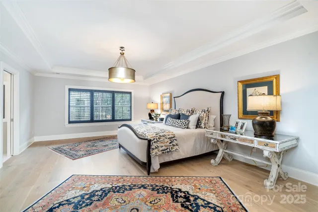 a bedroom with a bed a chandelier and a window