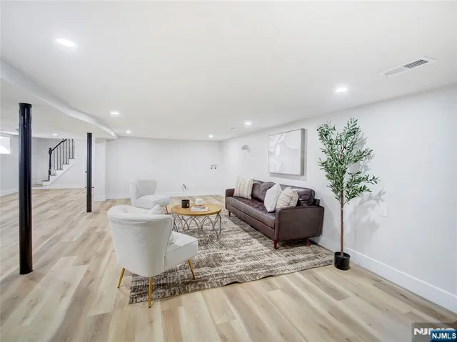 a living room with furniture a wooden floor and a potted plant