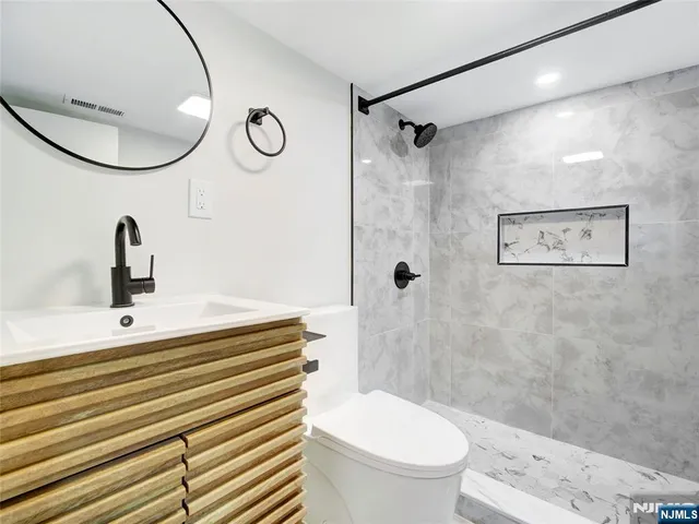 a bathroom with a sink a toilet and a mirror