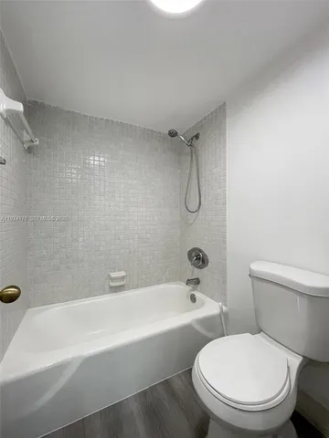 a white toilet and tub sitting next to a bathroom sink