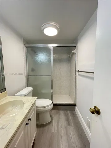 a bathroom with a granite countertop toilet sink and shower