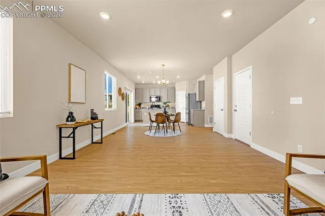 a living room with furniture and a dining table with wooden floor