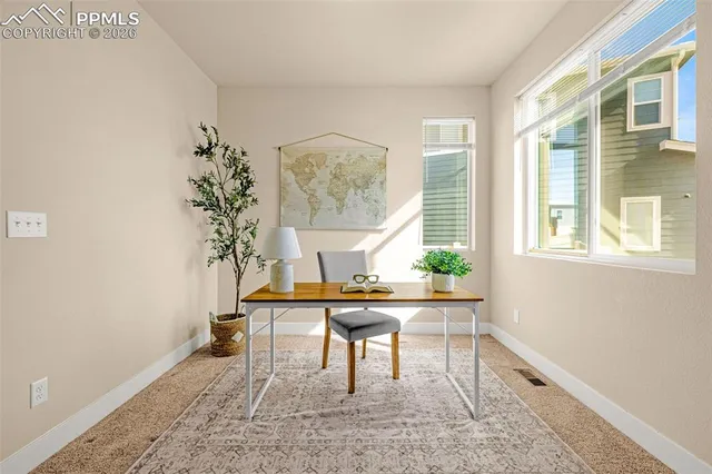 a view of a workspace with furniture and a window