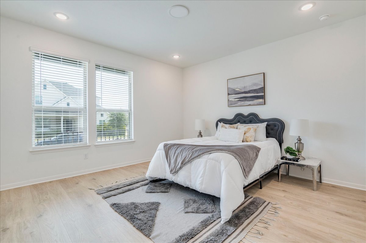 223 Rieber Road Kyle, TX 78640 - Photo 11 of 40 Smooth wood floors and recessed lighting enhance this airy bedroom.