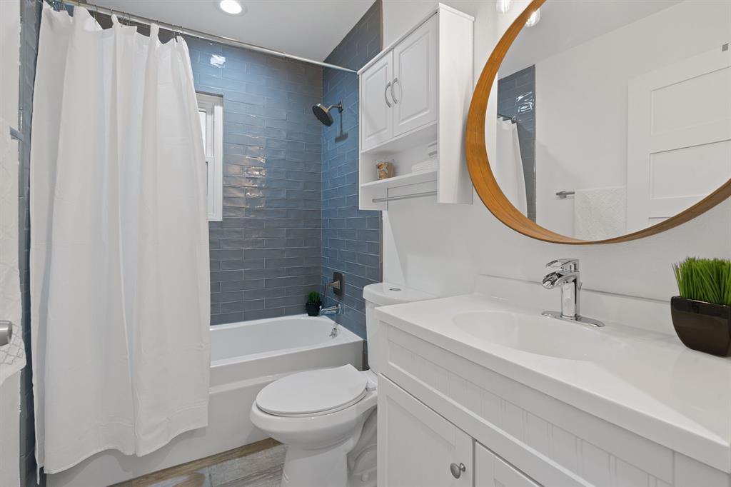 5211 Halmark Drive Austin, TX 78723 - Photo 18 of 27 A well-appointed bathroom offers sleek subway tile in the shower and a bright vanity with ample storage.