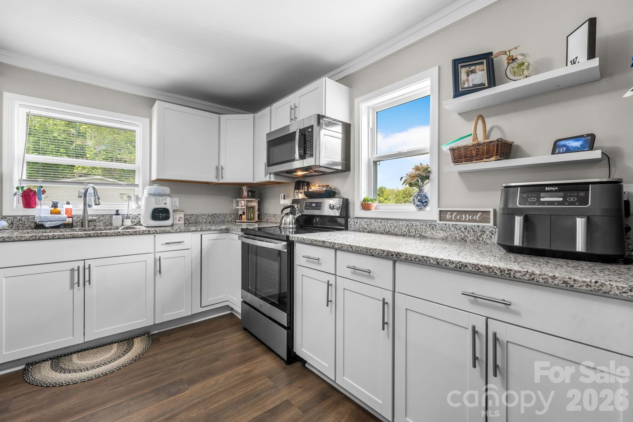 3941 Springs Road Northeast Conover, NC 28613 - Photo 9 of 21 a kitchen with granite countertop white cabinets and window