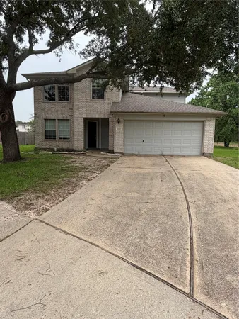 a front view of a house with a garden and trees