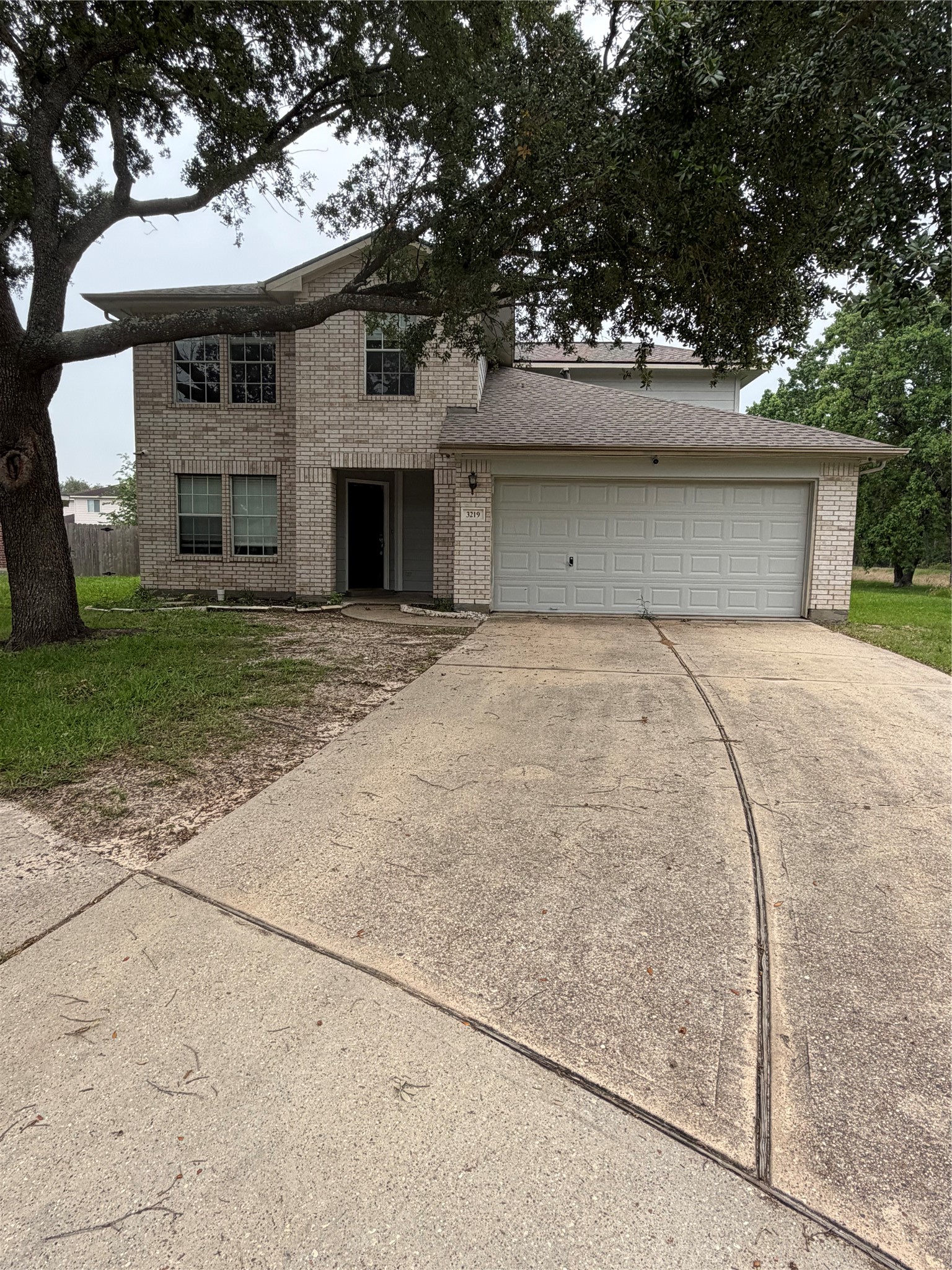 a front view of a house with a garden and trees