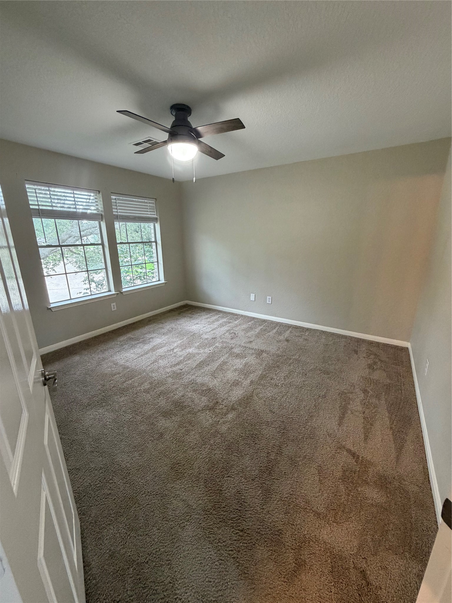 3219 Watercliff Court Spring, TX 77388 - Photo 9 of 21 en empty room with windows and ceiling fan