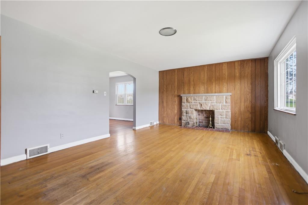 64 Harmon Creek Road Burgettstown, PA 15021 - Photo 5 of 29 an empty room with wooden floor fireplace and windows