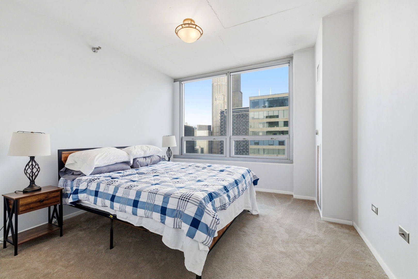 701 South Wells Street, Unit 2801 Chicago, IL 60607 - Photo 20 of 32 a bedroom with a bed lamp and window