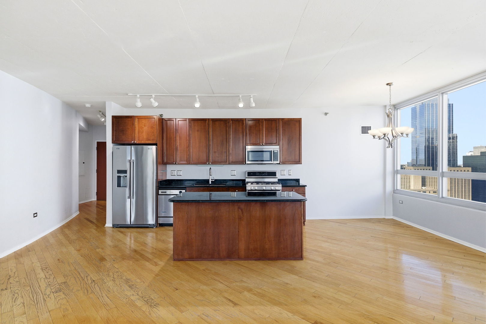 701 South Wells Street, Unit 2801 Chicago, IL 60607 - Photo 6 of 32 a kitchen with stainless steel appliances a refrigerator and a wooden cabinets
