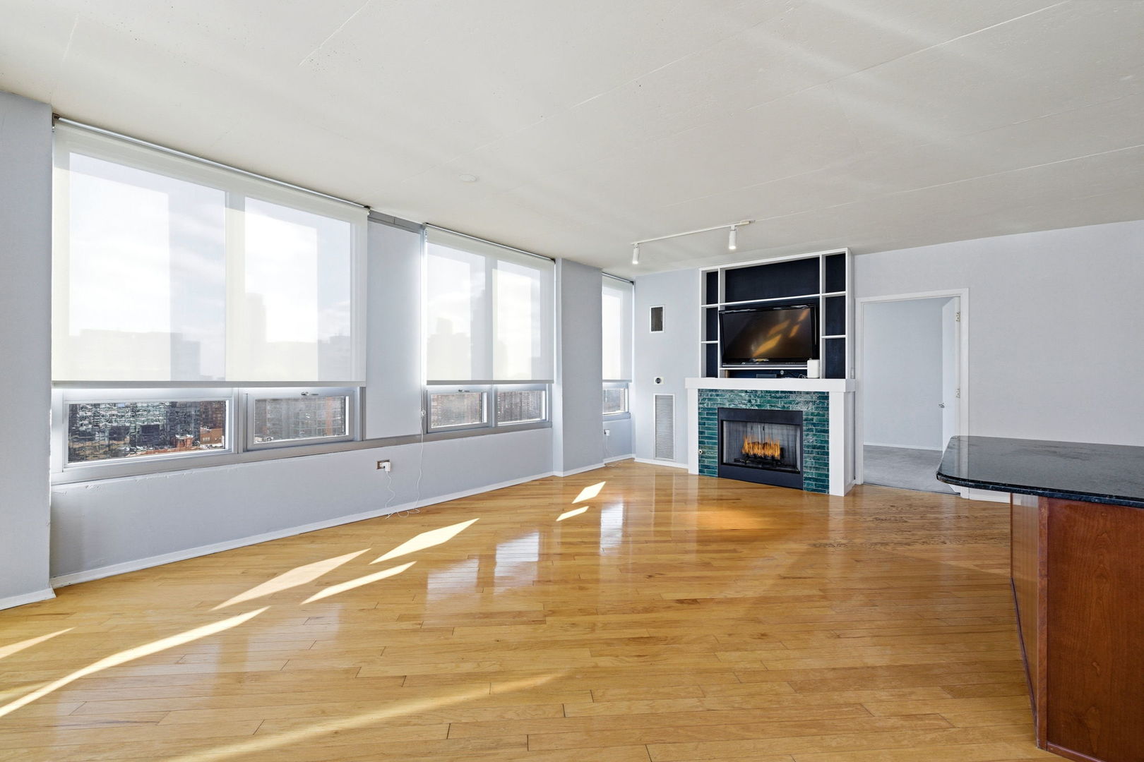 701 South Wells Street, Unit 2801 Chicago, IL 60607 - Photo 10 of 32 a view of an empty room with a fireplace and a flat screen tv