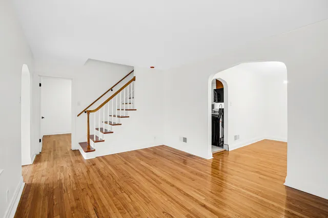 a view of empty room with wooden floor and stairs